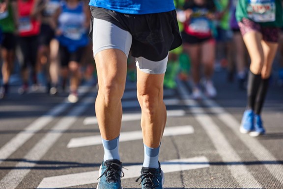 A runner competes on a road alongside several other participants during a race event.
