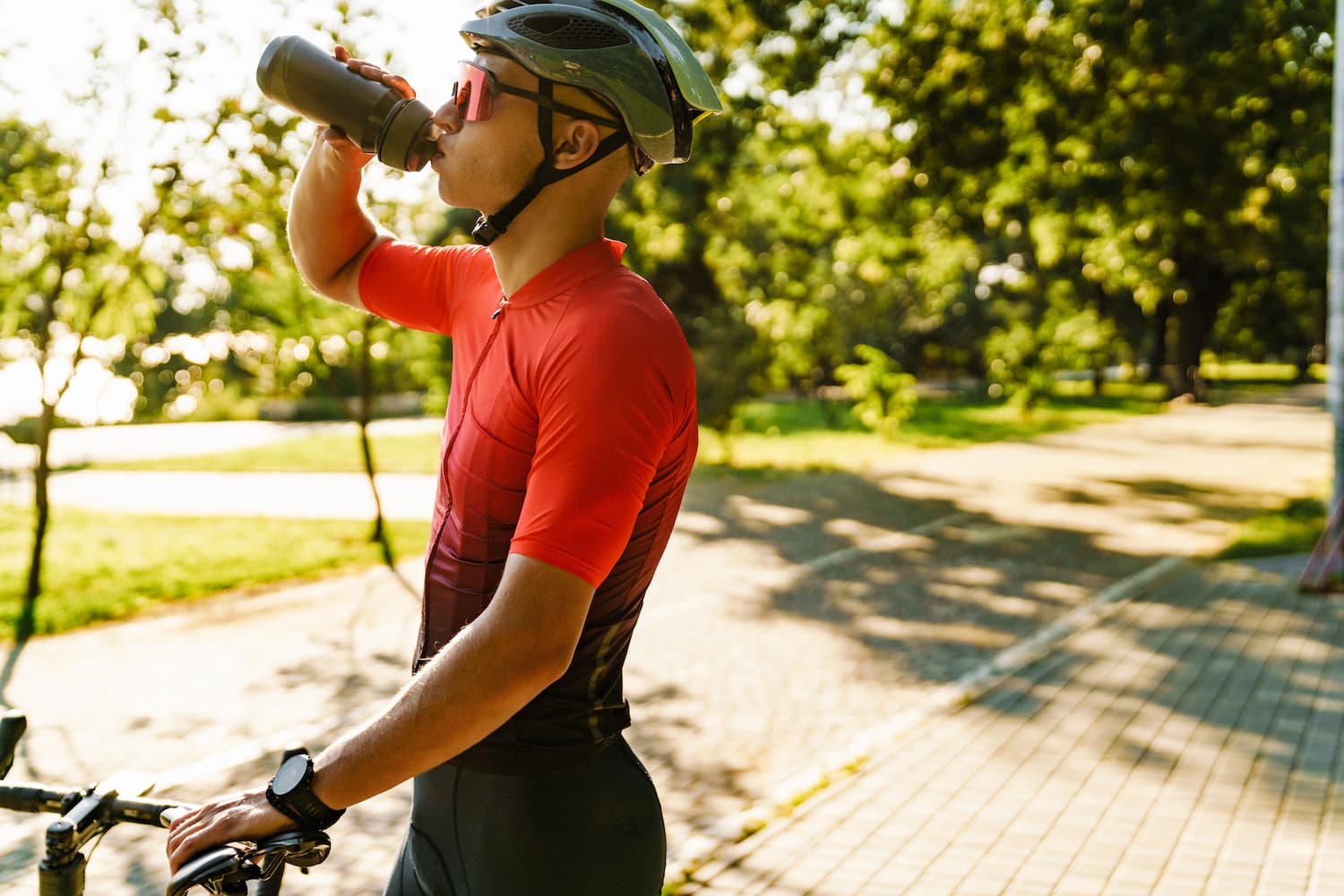 man-cycling-and-hydrating-on-a-sunny-day